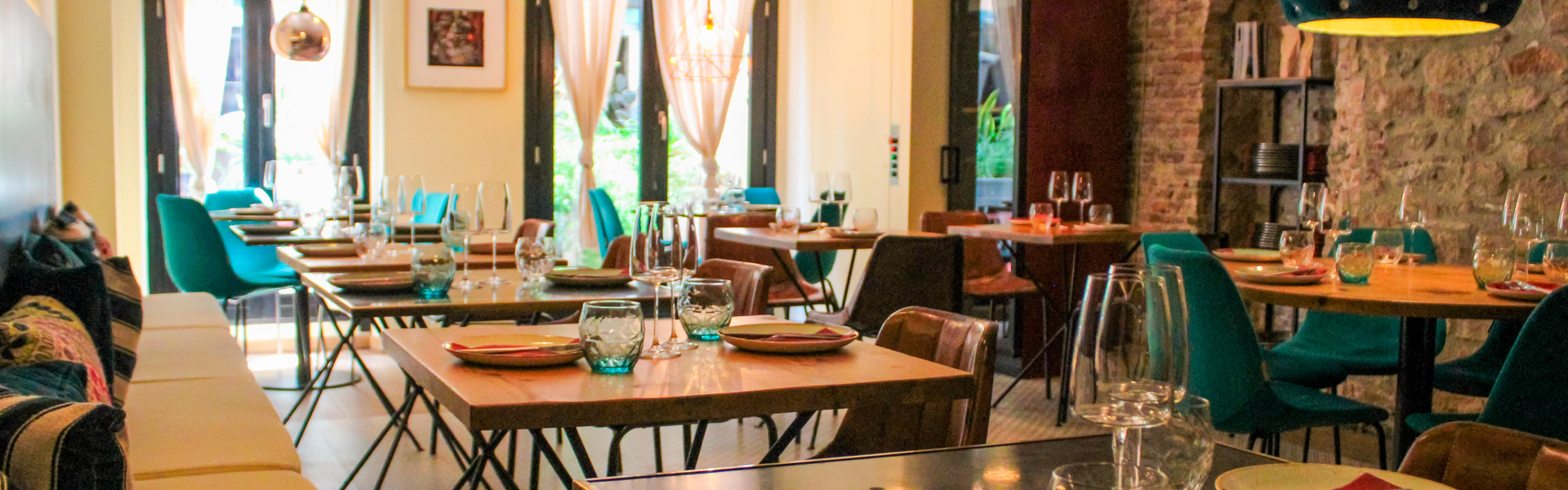 Interior of My Fucking Restaurant with turquoise chairs and stone walls